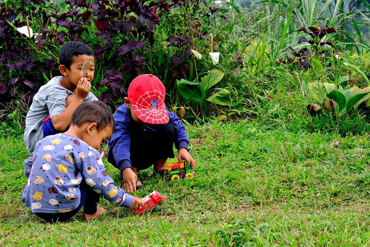 Children playing outdoors in a park, running, climbing, and exploring nature.